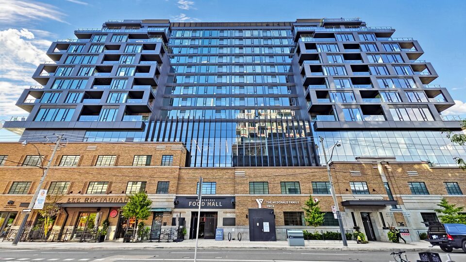 Street view of the building, with the brick heritage base housing the Food Hall and YMCA below the black glass and metal residential floors