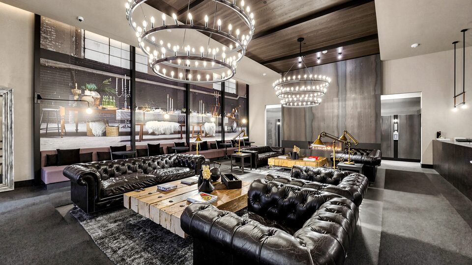Lobby lounge with leather chesterfield sofas, reclaimed timber tables and two large ring chandeliers