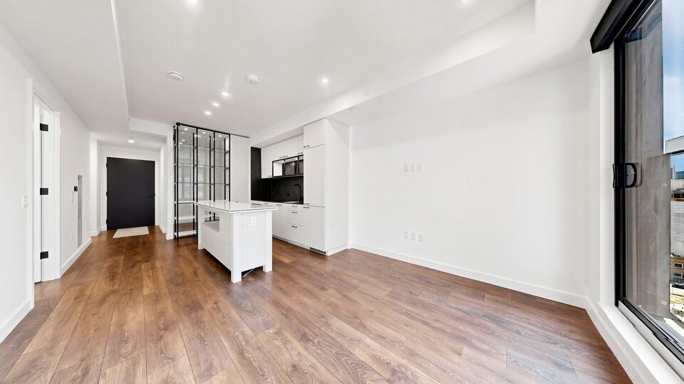 View from the living room back towards the entry door, past the kitchen island